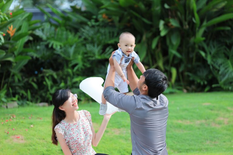 A joyful family playing in a lush garden, showcasing love and happiness outdoors.